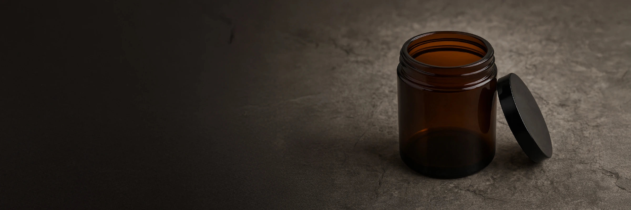 Amber cosmetic glass jar with black lid