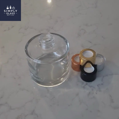 Gold diffuser caps next to clear glass diffuser bottle