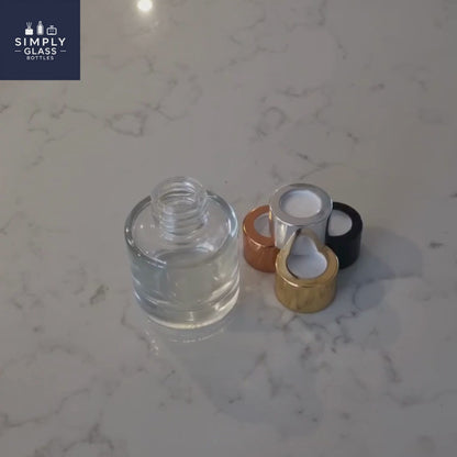 Silver diffuser cap next to glass bottle